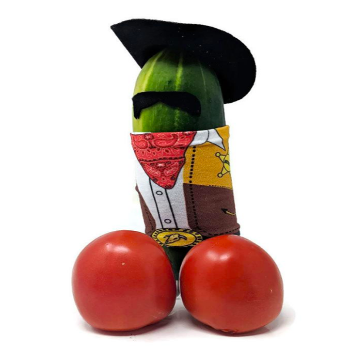 Cucumber with two cherry tomatoes in front of it. The cucumber is wearing a hat, mustache, and cowboy outfit.