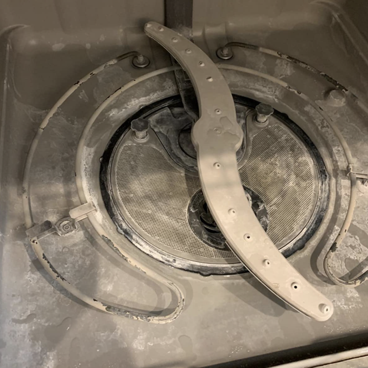 The inside of a reviewer's dishwasher looking dirty 