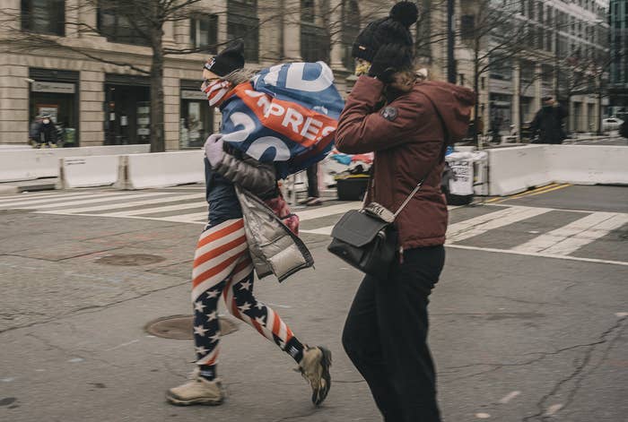 A woman dressed in flag tights and wearing a Biden flag
