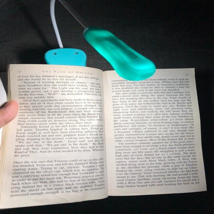 a reviewer using the blue book light to read in the dark