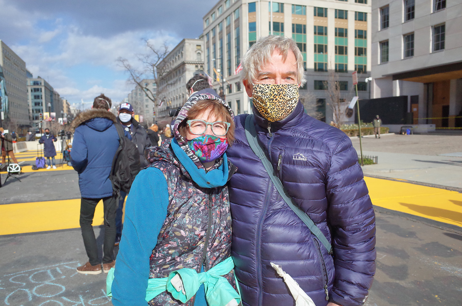 A man and a woman in winter parkas and masks