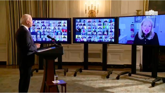 Three screens show dozens of faces watching Biden