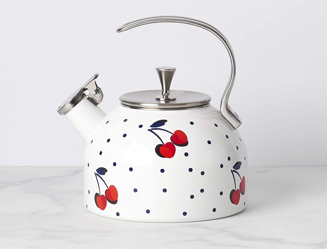 The polka-dotted white kettle which has a cherry pattern