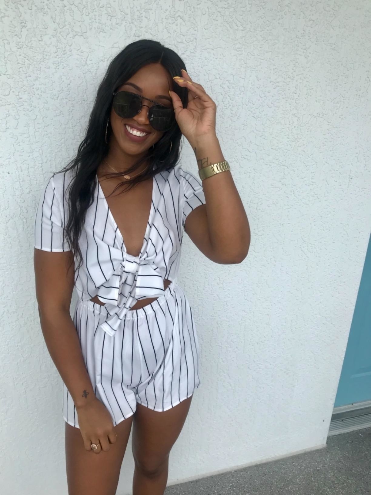 Reviewer wearing tie-front short-sleeve black and white romper with shades