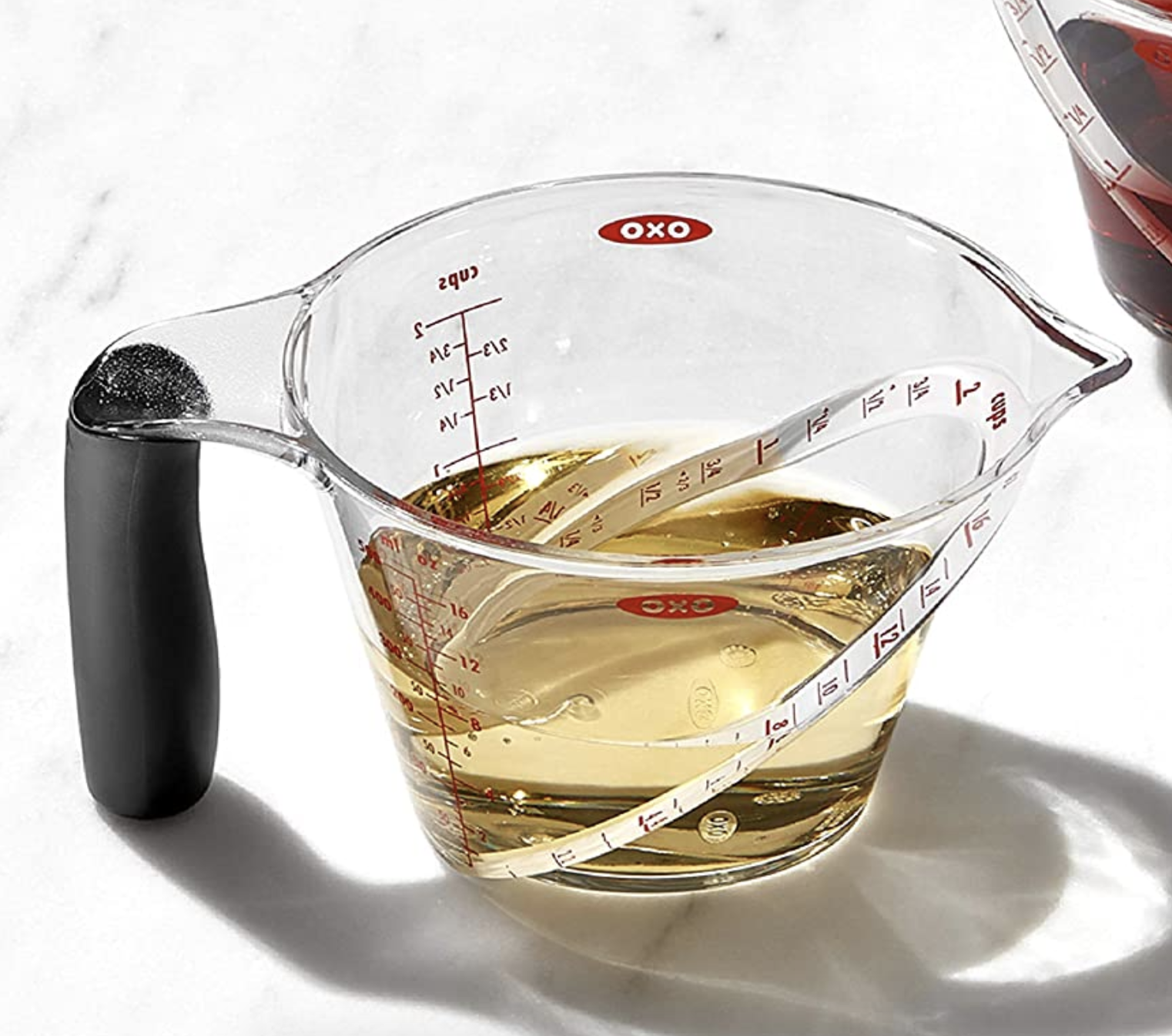 The transparent angled measuring cup with oil inside 