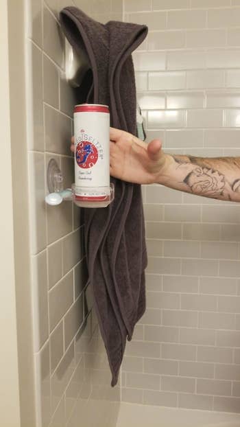Reviewer reaches for a beer in the drink holder in the shower
