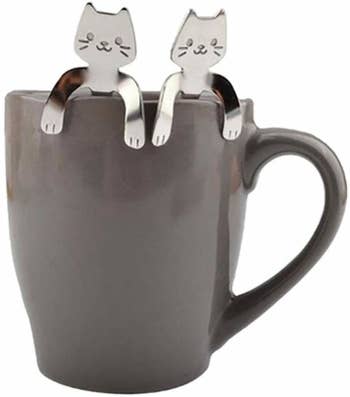 two of the cat spoons in a mug