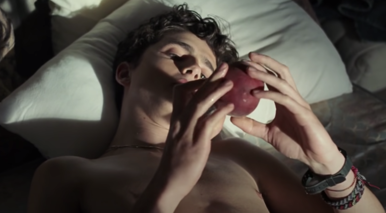 Timothée Chalamet staring at a peach in bed in &quot;Call Me by Your Name&quot;