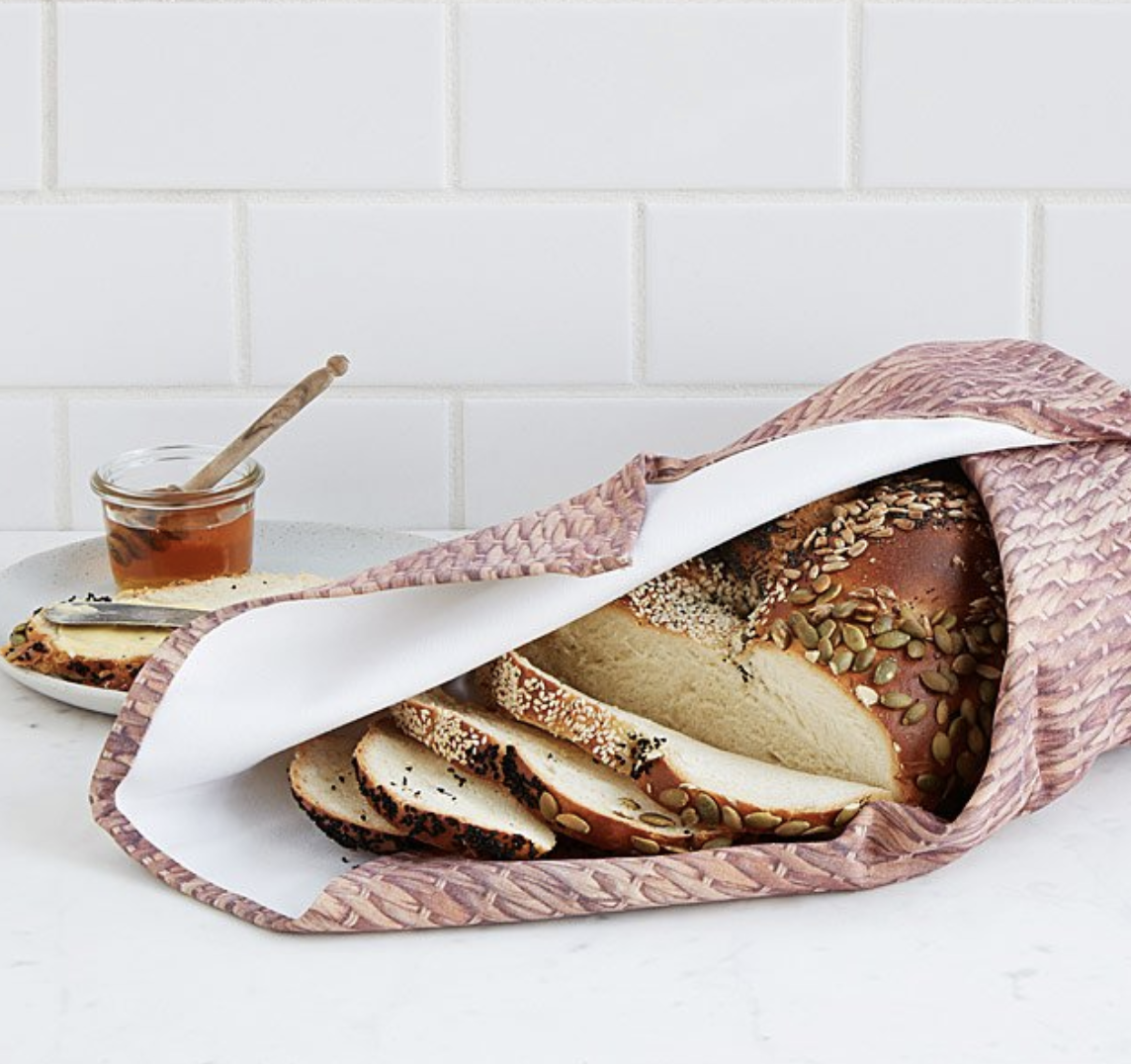 A loaf of bread wrapped around a large blanket with basket weave pattern