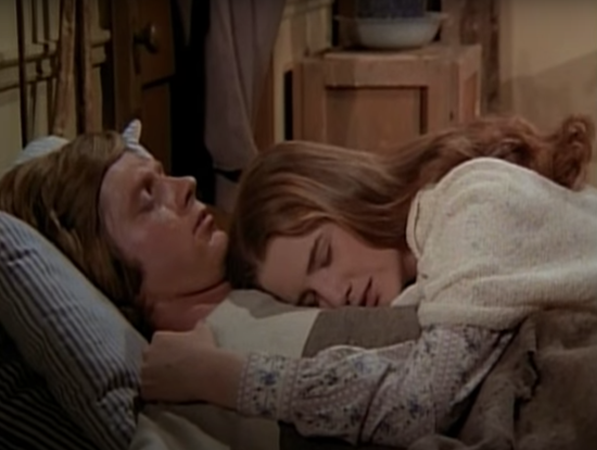 Melissa Gilbert lying on Dean Butler&#x27;s chest in a scene from the show