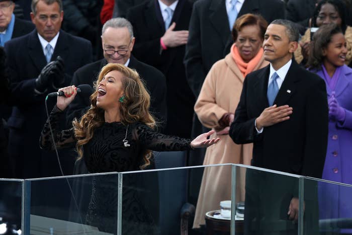 Beyoncé is sporting long wavy hair and is wearing a long gown as she belts out the song