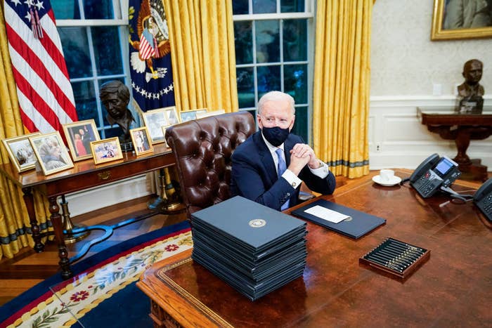 Joe Biden sitting at the Resolute Desk in the Oval Office after his swearing-in ceremony