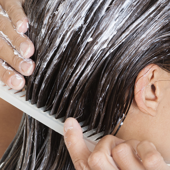 Model combing hair mask through hair