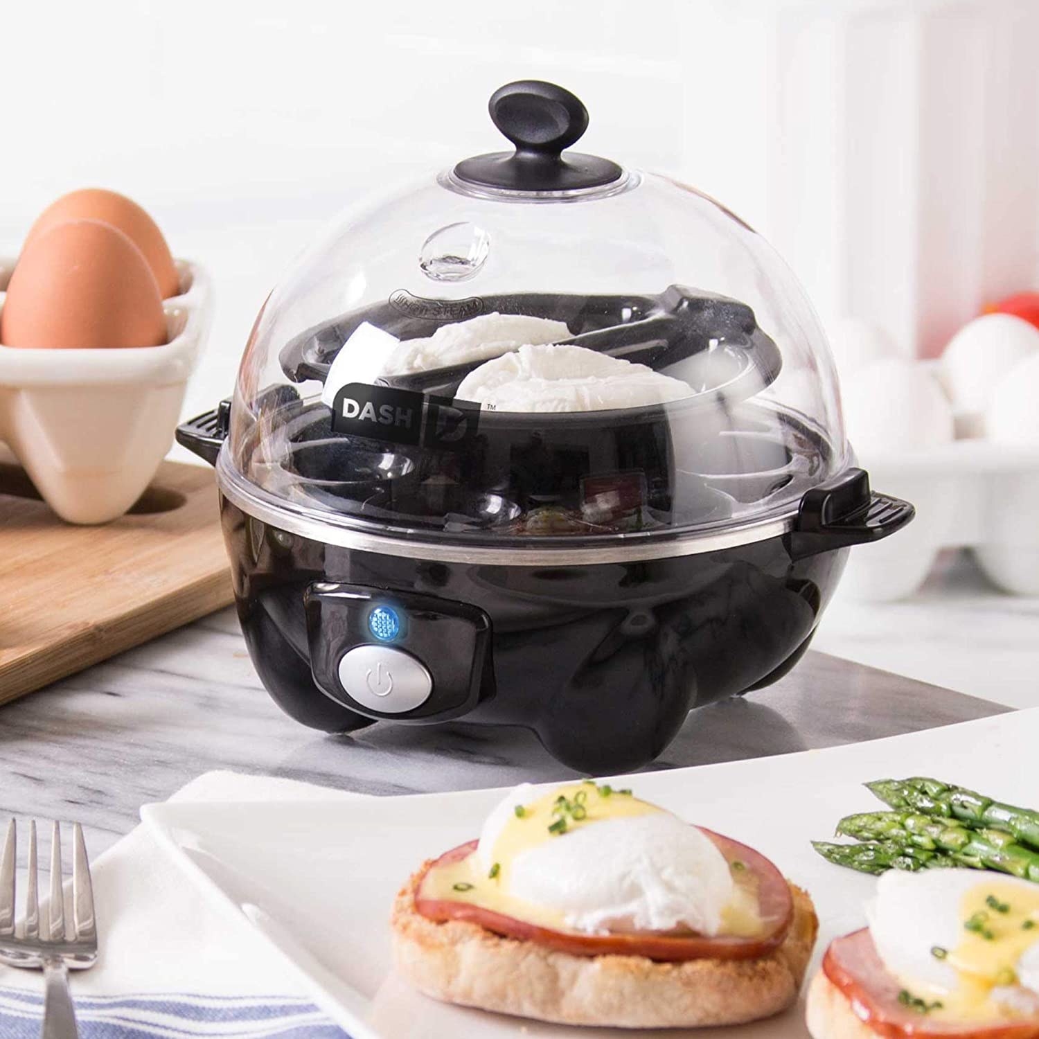 Rapid egg cooker on table next to breakfast sandwich