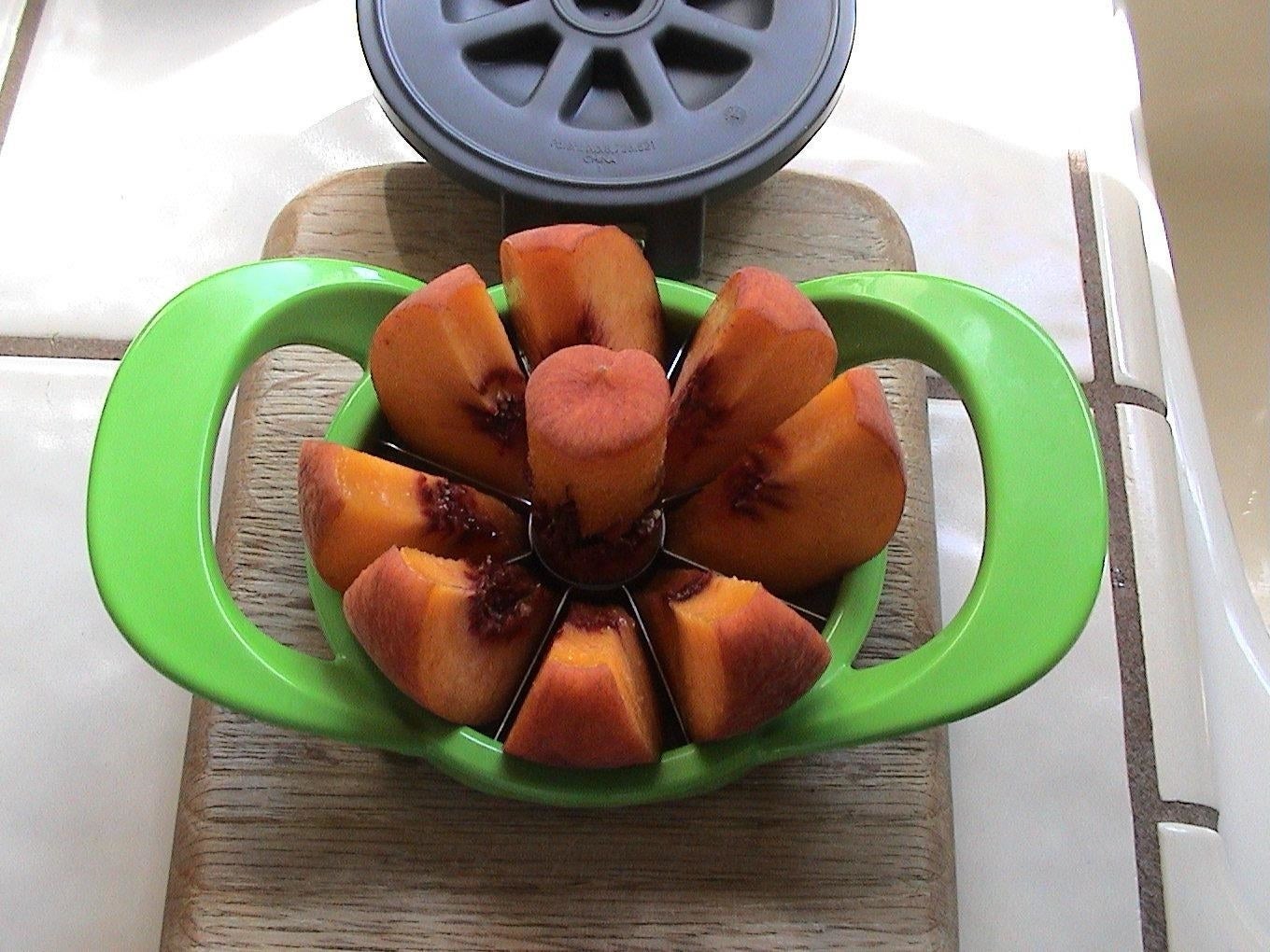 Reviewer&#x27;s apple slicer in use on peach