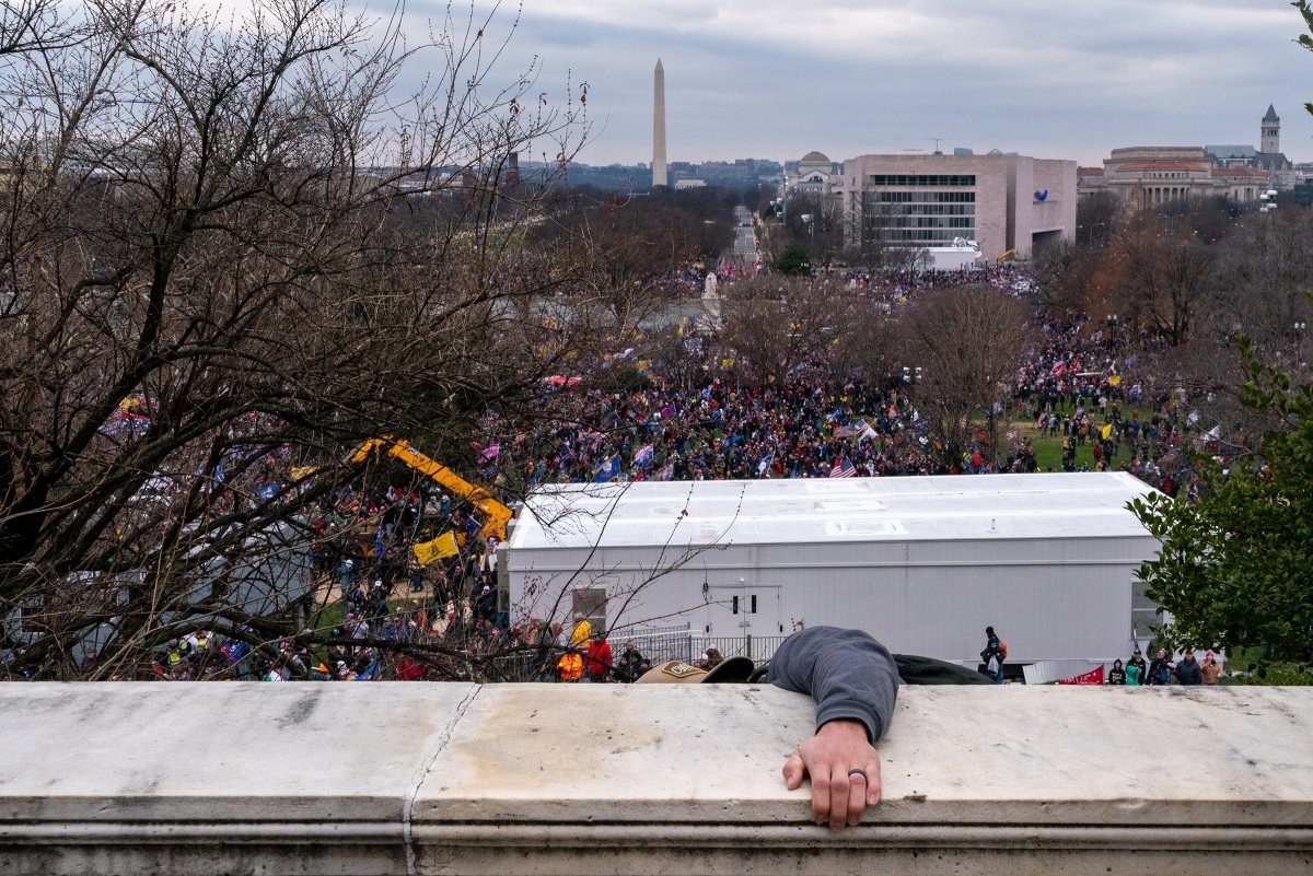 A man climbs over the barrier at the Capitol on the attempted coup 