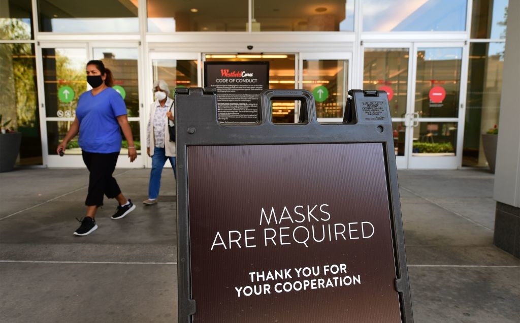 a sign outside a mall that says &quot;masks are required&quot;