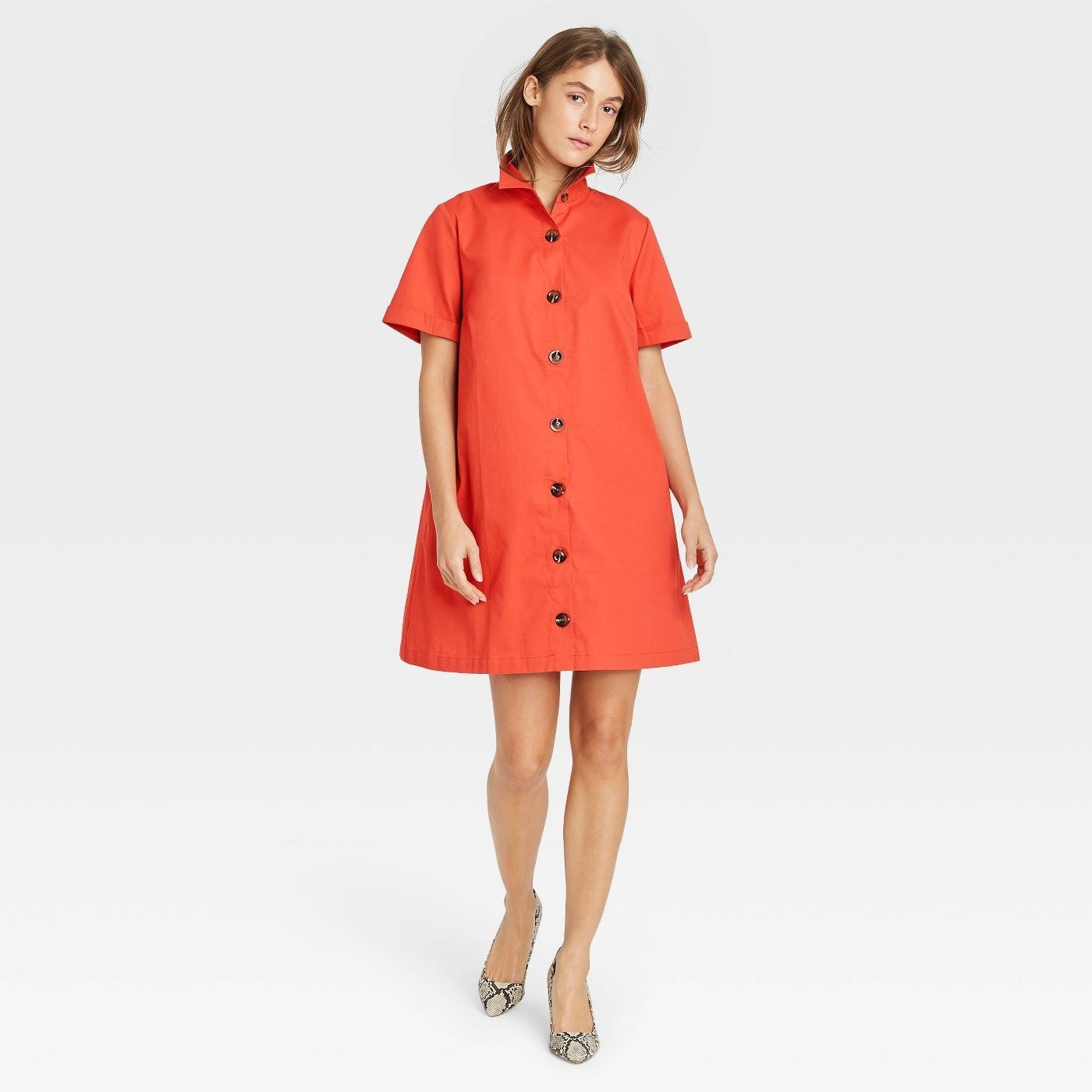 Model in short sleeve button-up trapeze dress