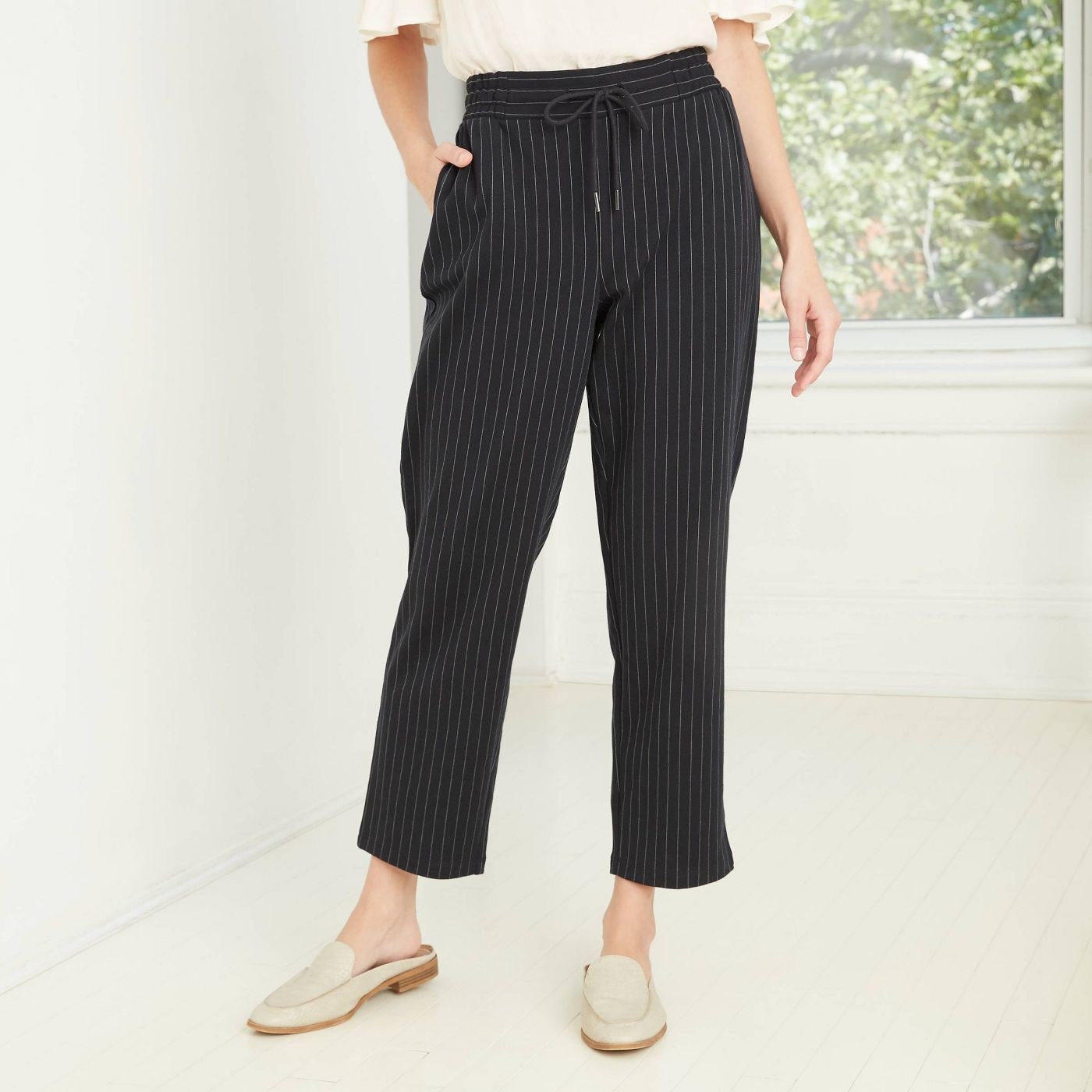Model in pinstripe high-rise ankle knit pants 