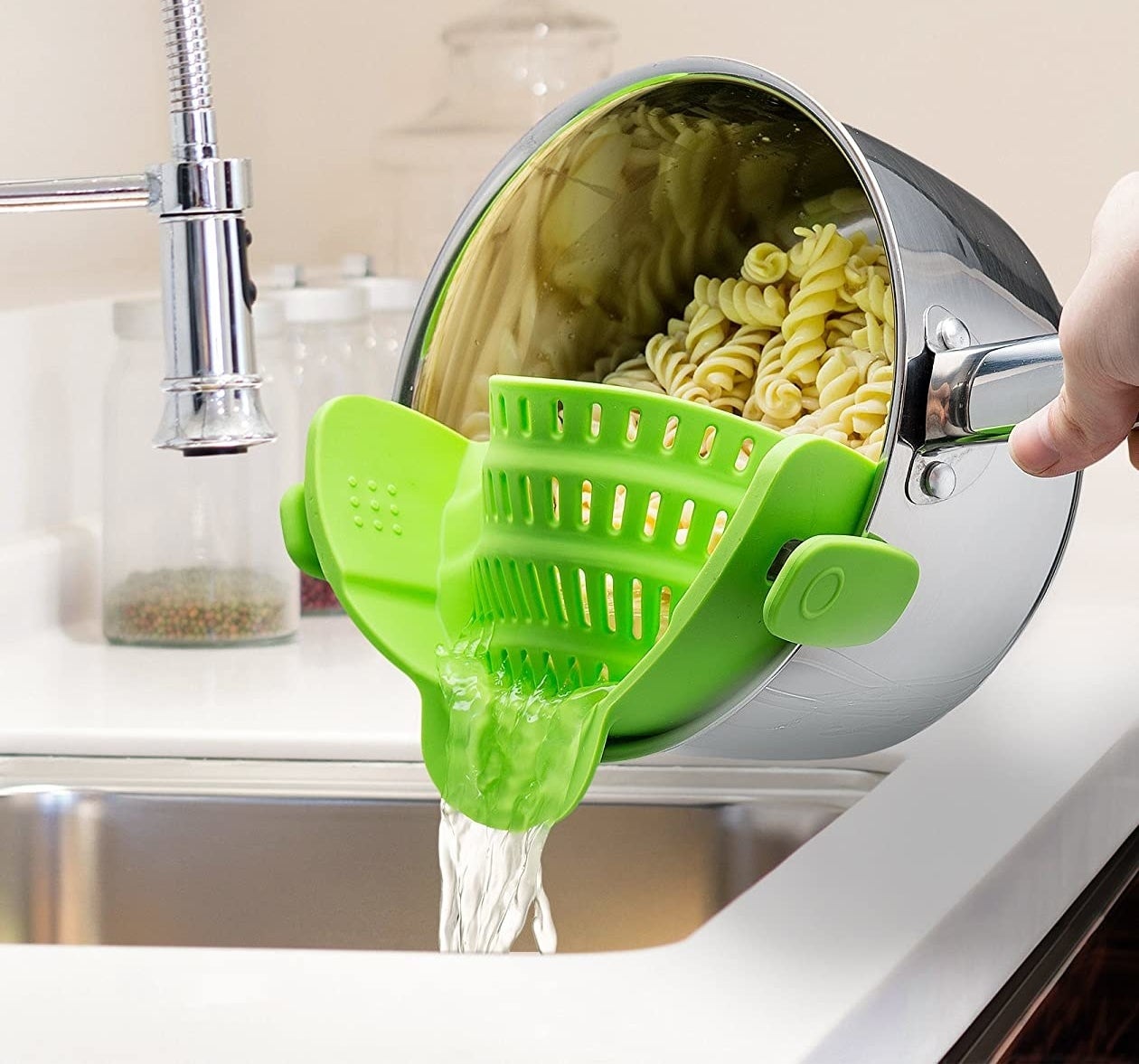 Model using silicone colander on pot over sink