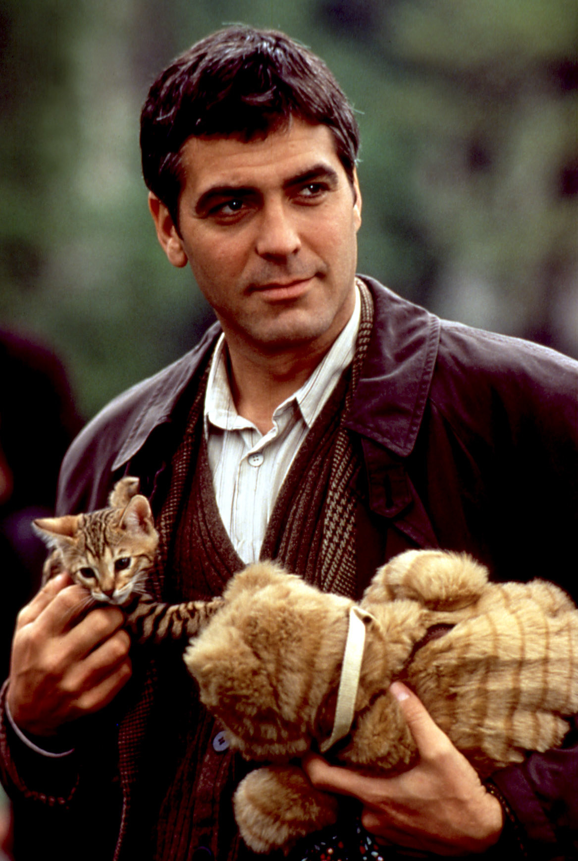 George Clooney holding a cat and a stuffed animal in One Fine Day