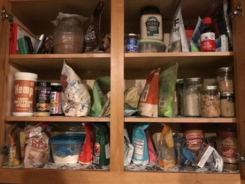 reviewer photo of messy cabinets filled with packages of food