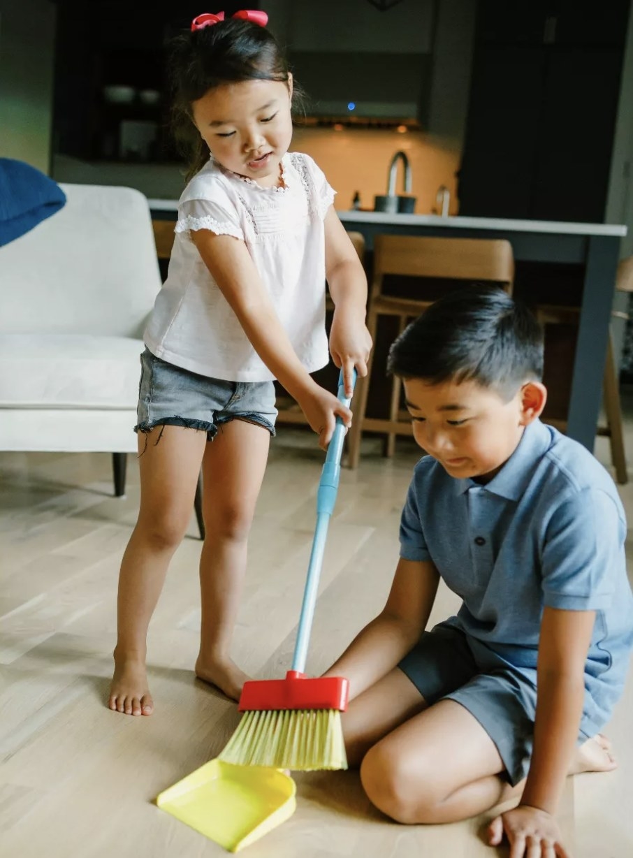 Two young people sweeping the floor