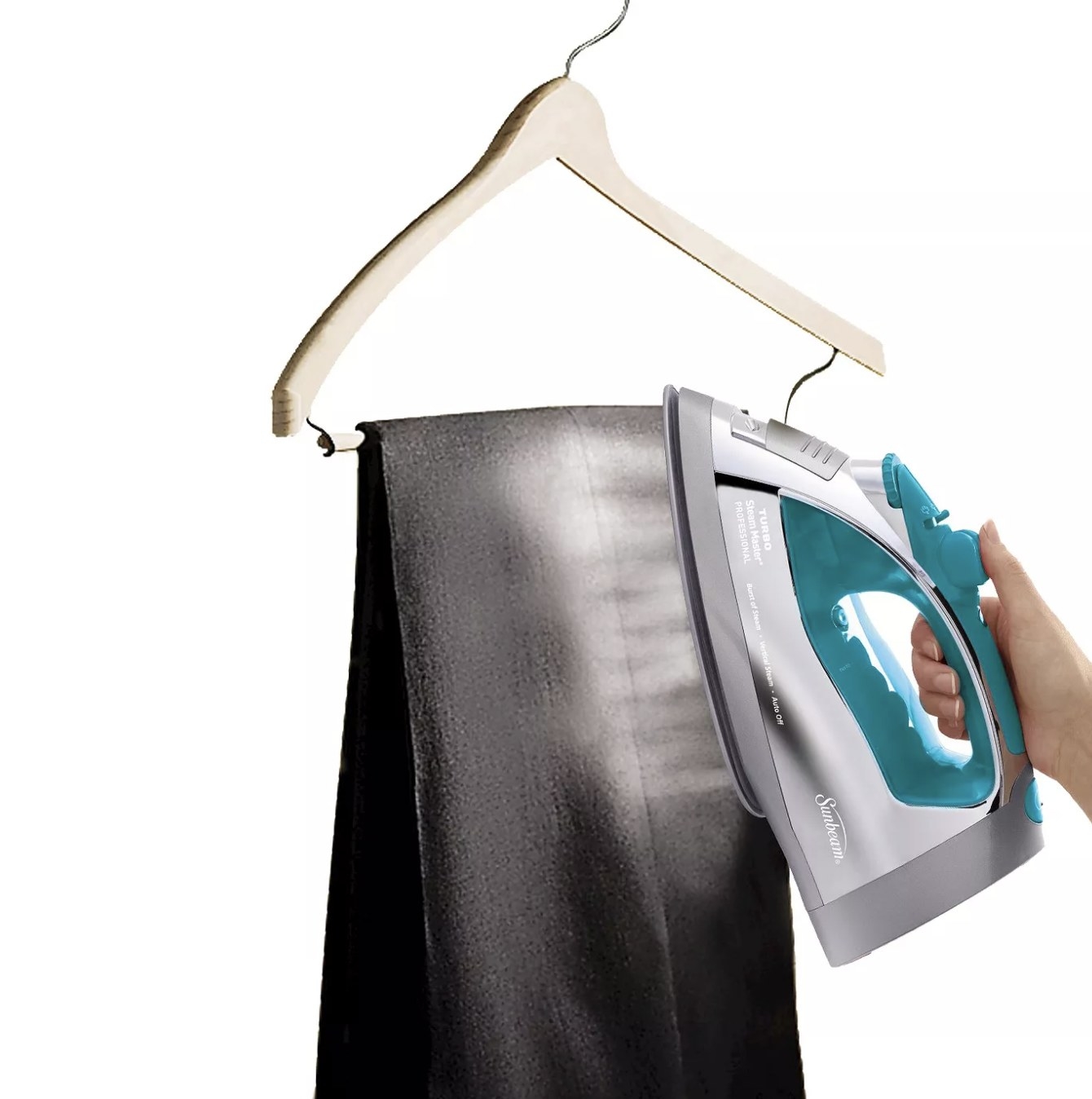 A person is steaming a pair of black pants with an iron