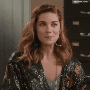 A gif of Alexis Rose from &quot;Schitt&#x27;s Creek&quot; flipping her hair