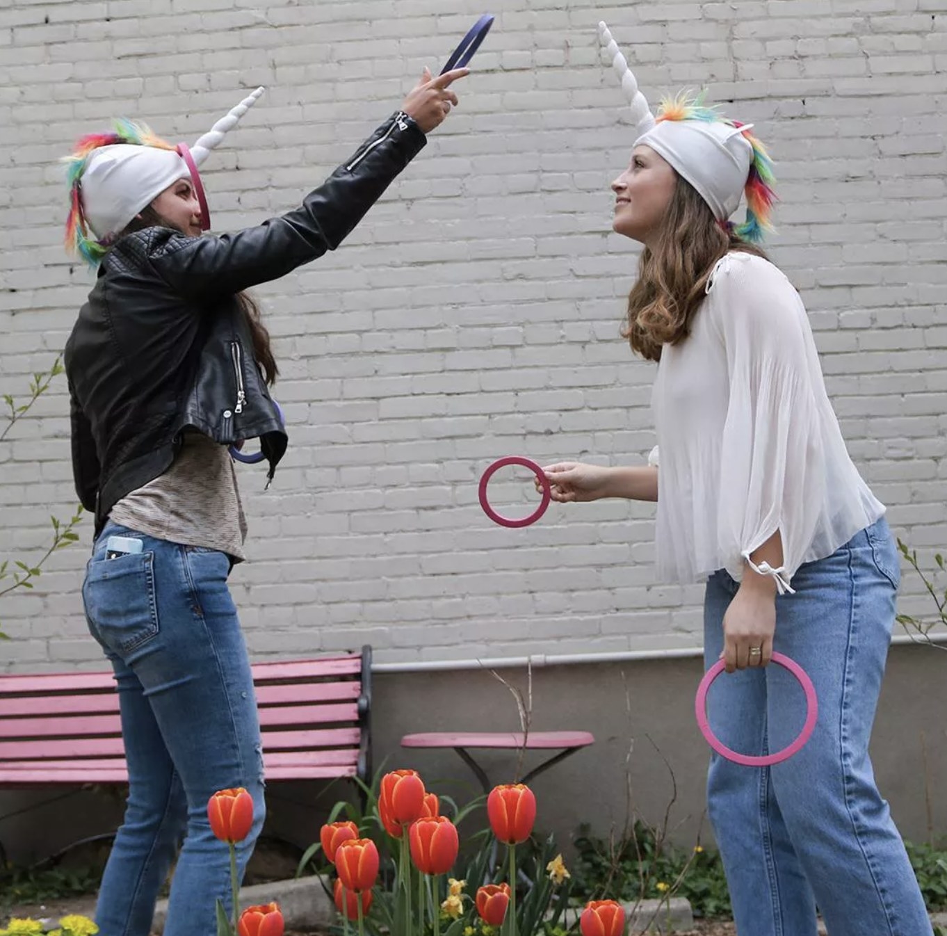 Two people playing the unicorn ring toss game