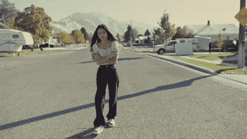Olivia Rodrigo walking down a neighborhood street in the Drivers License music video