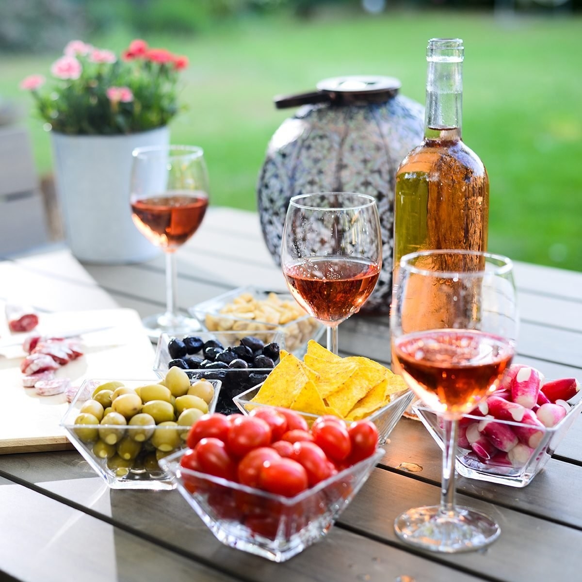 Wine glasses on a table with fruit and crackers