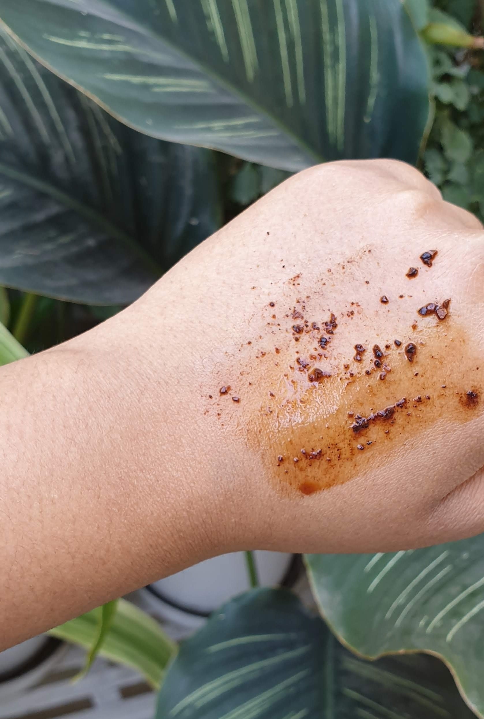 The coffee body scrub pictured on my hand, mixed with water.