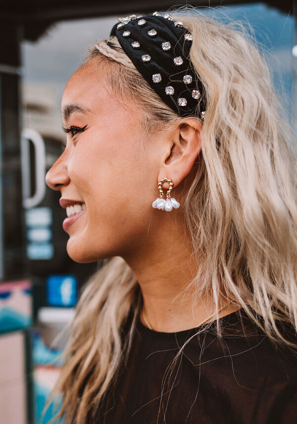 A person wearing the earrings and a headband