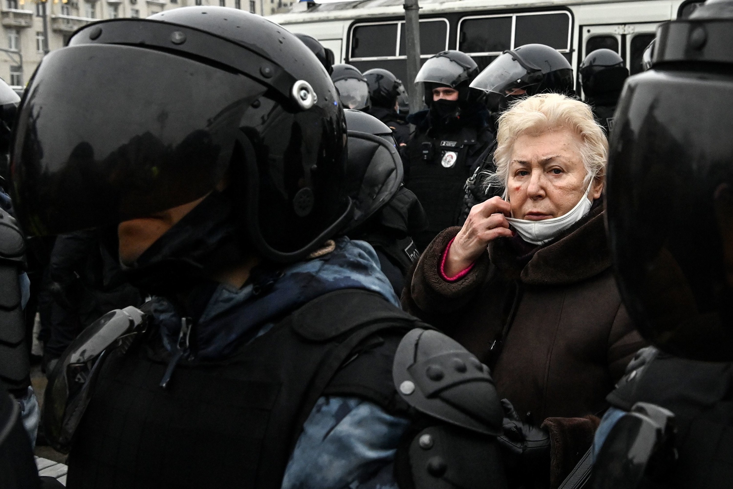 An elderly woman surrounded by police officers at a pro-Democracy rally in Russia