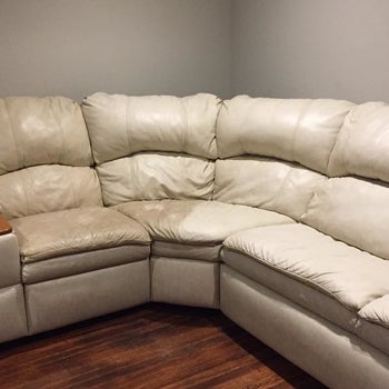 reviewer photo showing their white sectional half dirty, half cleaning restored after using the leather honey