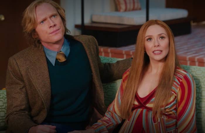 Wanda and Vision wearing &#x27;70s clothes sit on a couch looking uncertain