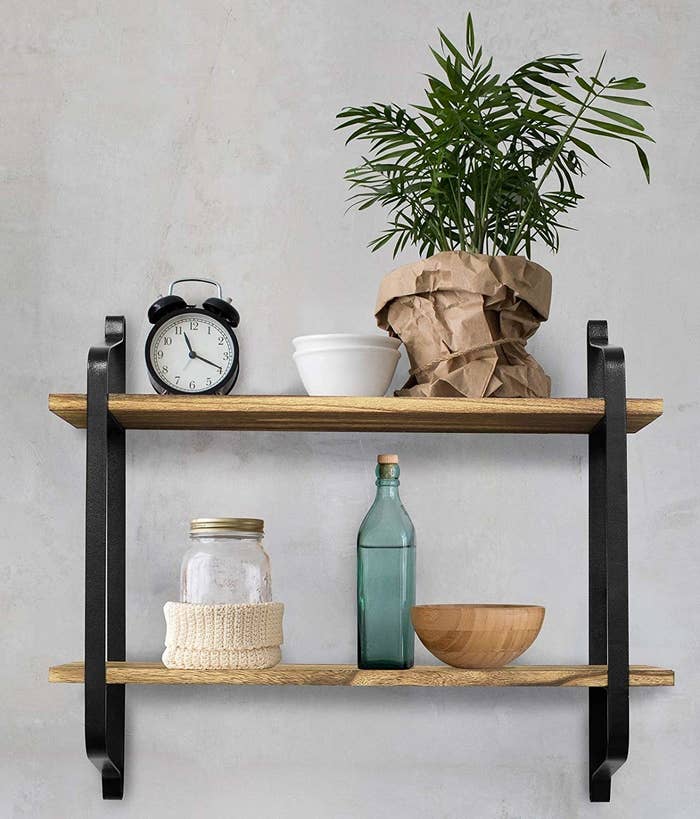 two wooden shelves on black metal brackets on a wall