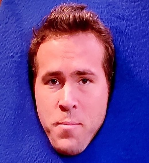 A closeup of Ryan&#x27;s face in the opening of the letter &quot;A&quot; costume