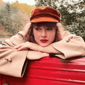 Taylor Swift sitting in a car and winking