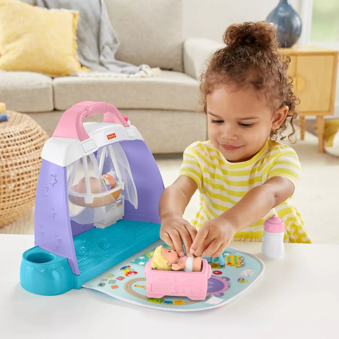 A child playing with one of the babies in the nursery playset