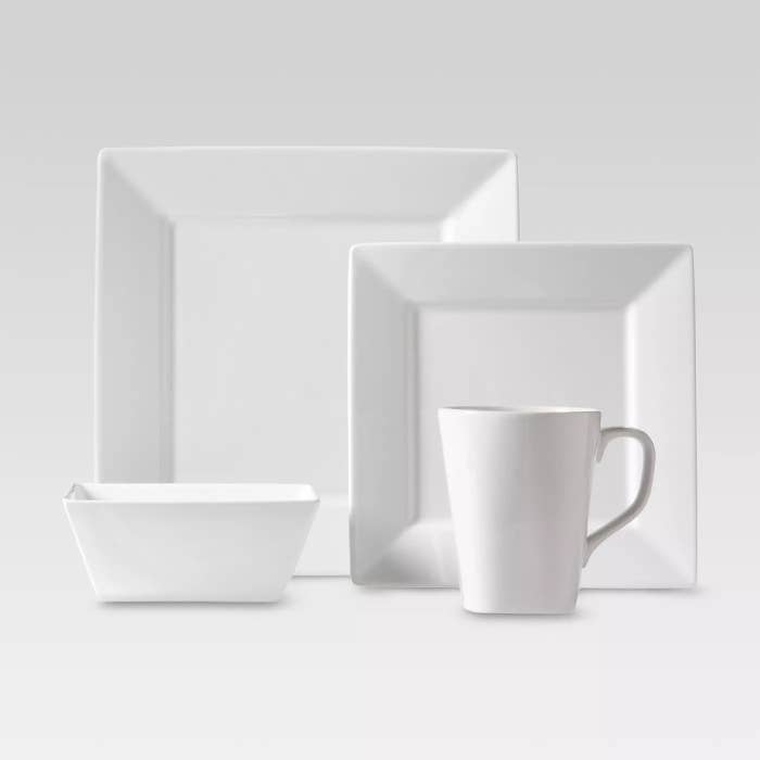 A white mug, a white bowl, and two white plates