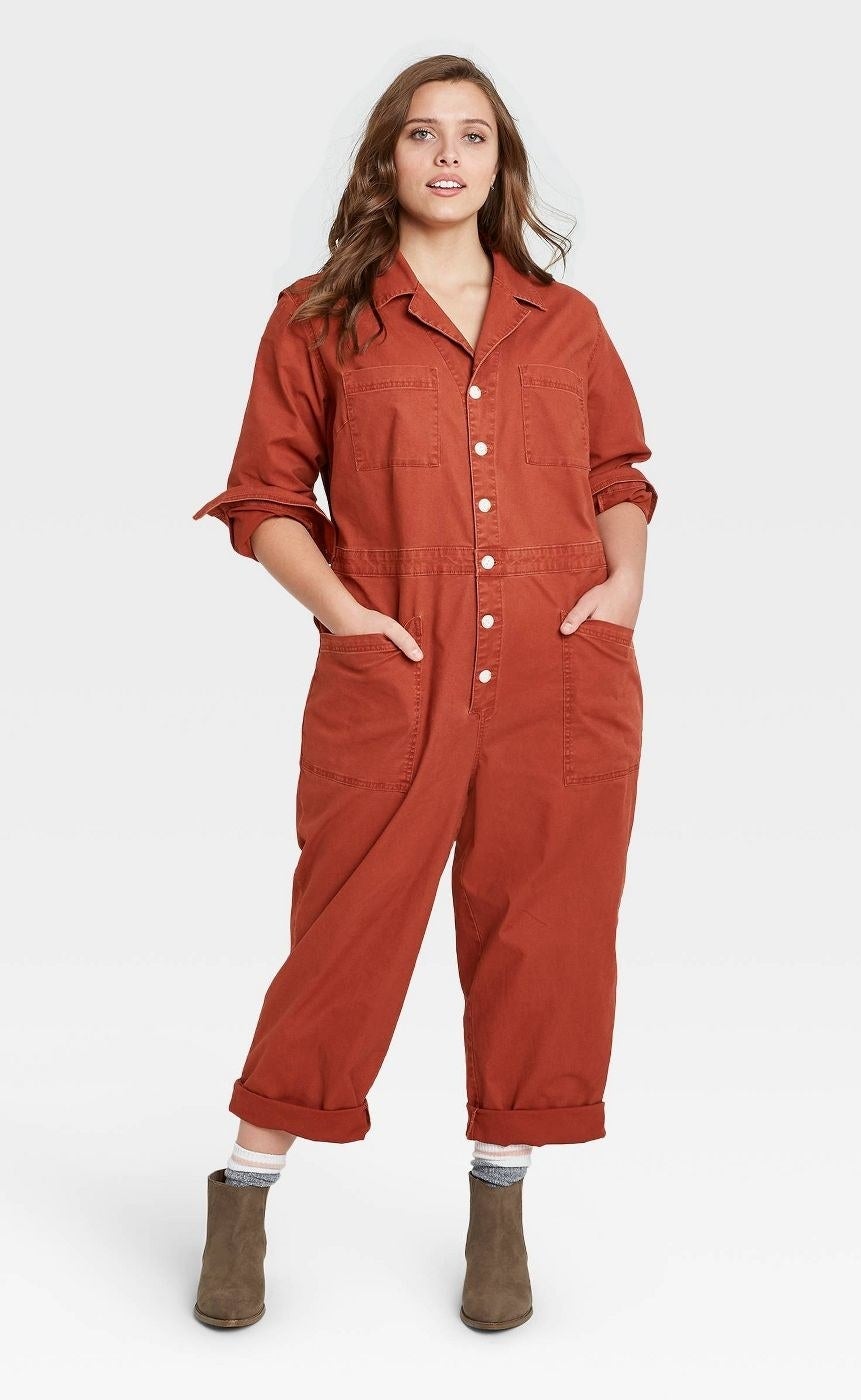 Model wears red long-sleeve collared boilersuit with brown booties