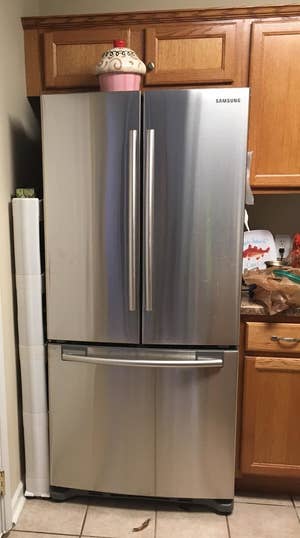A reviewer's photo of the sliding pantry tucked between the wall and their fridge