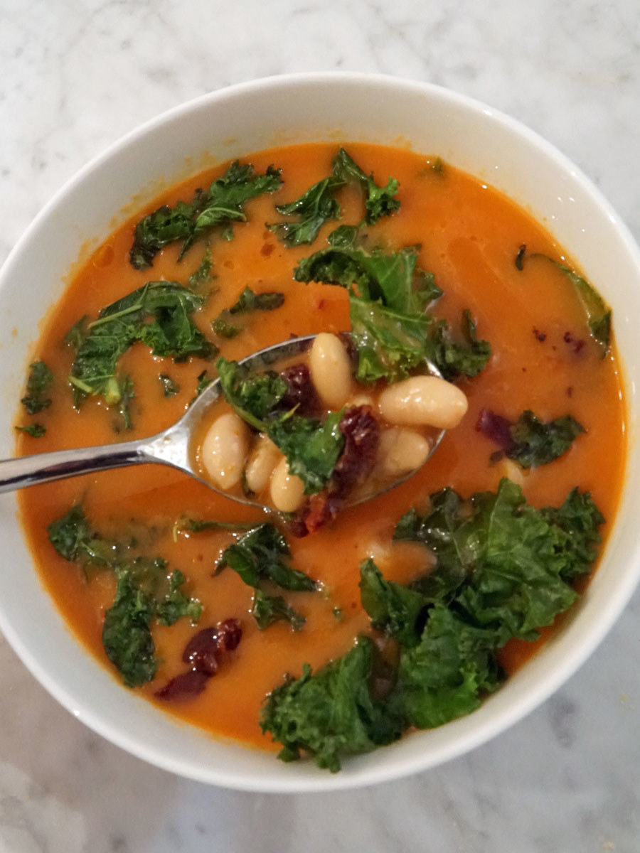 A bowl of Tuscan white bean soup with kale and sun dried tomatoes.