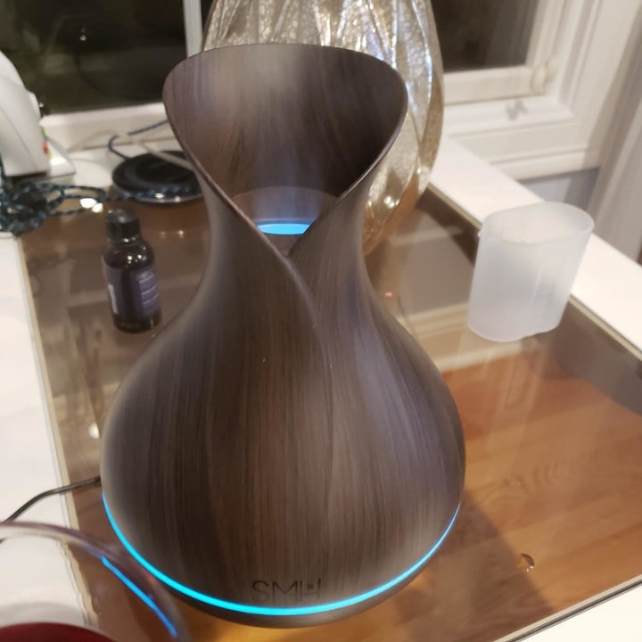 A reviewer photo of the diffuser with a band around the base illuminated blue 