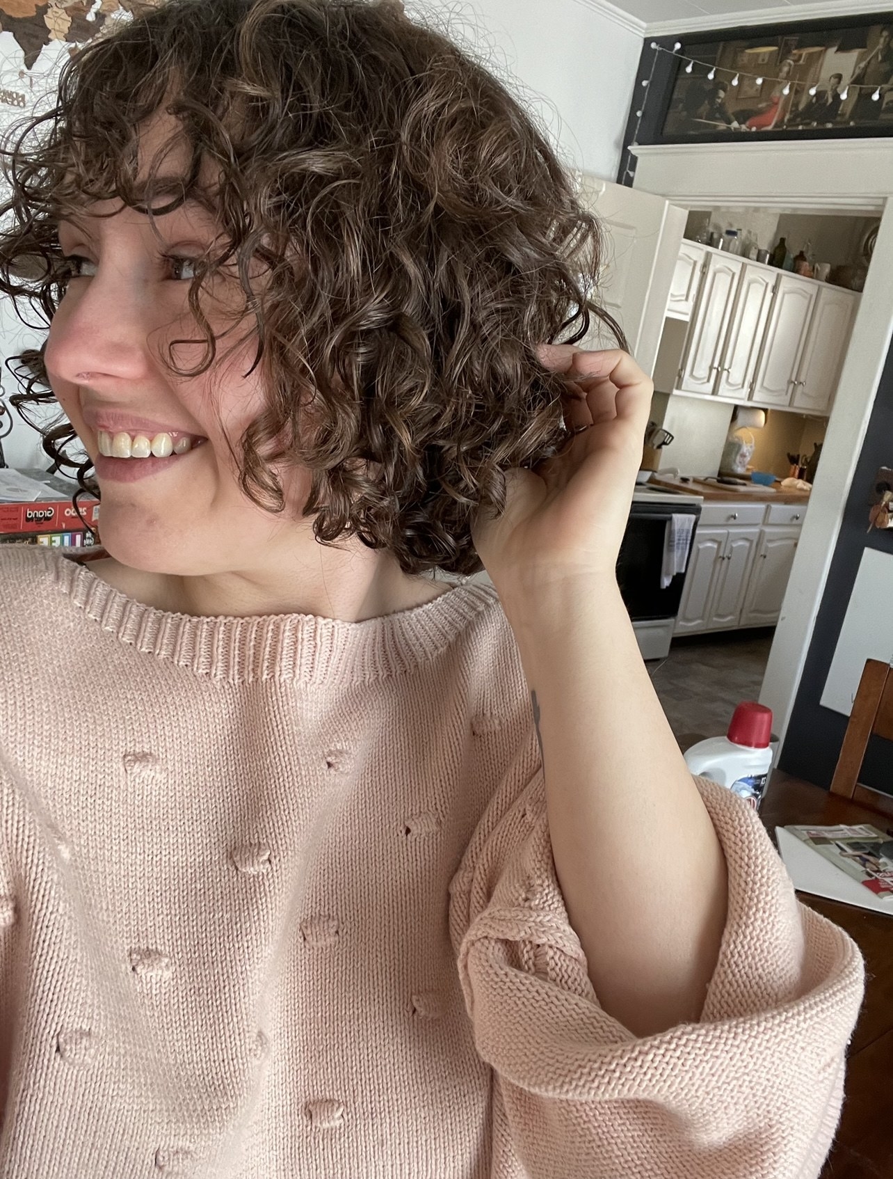 A person smiling and showing their curls