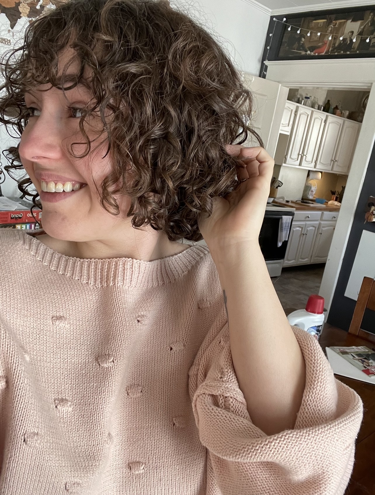 A person smiling showing their curls