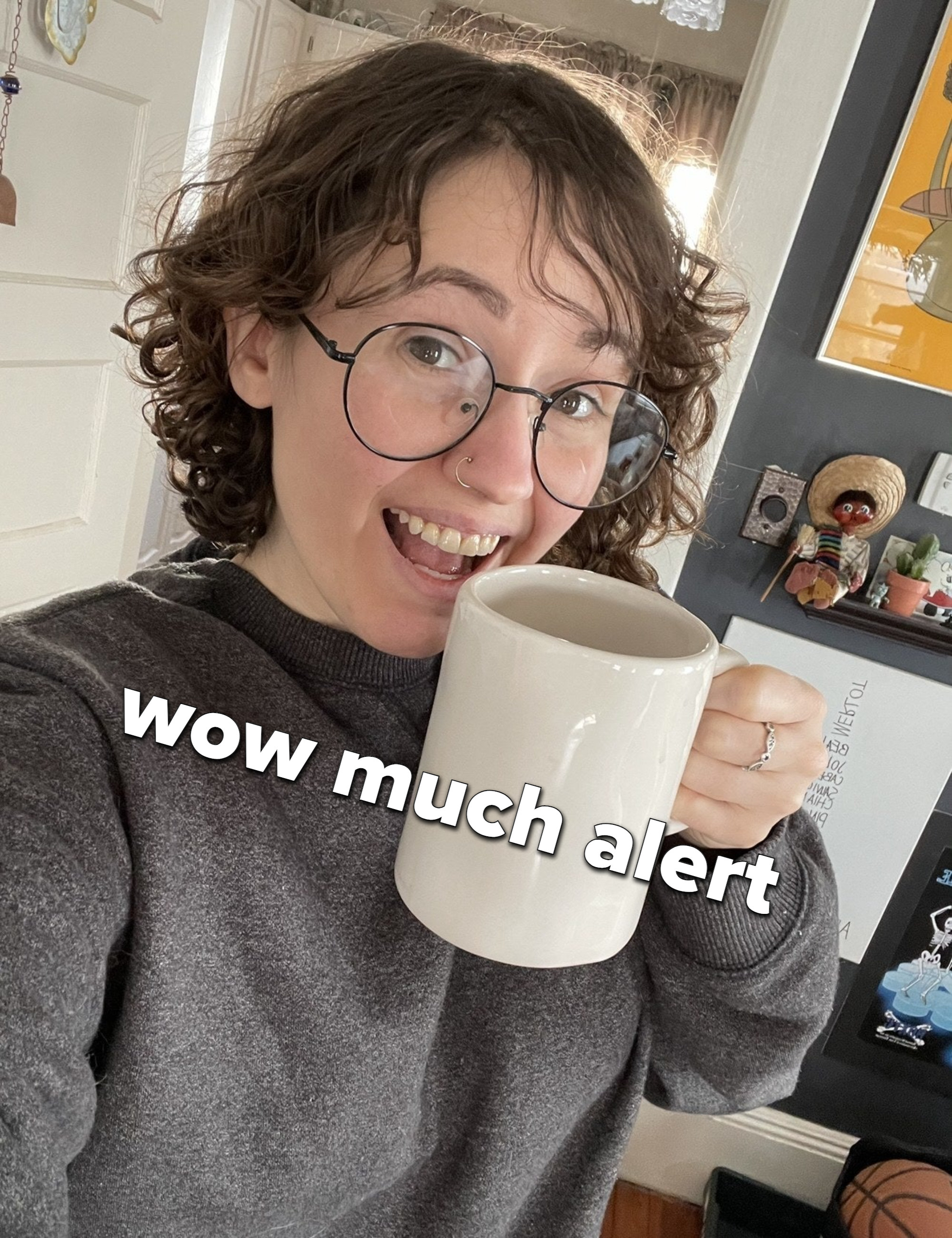 A person smiling with a mug full of coffee