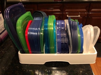 A reviewer's photo of the organizer filled with lids of all sizes